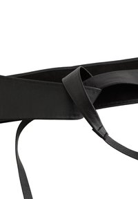 Svart läderbälte med en sömlös design, som har ett platt, brett rem och en tunn, justerbar svans. Strukturen är texturerad utan kronor.