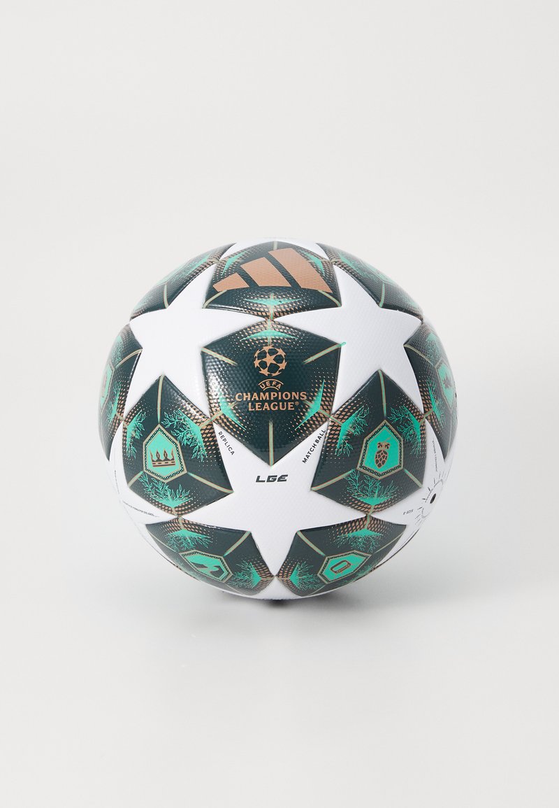 Vit fotboll med gröna och svarta stjärnpaneler, med UEFA Champions League-logotypen och en texturerad yta, tillverkad av syntetiskt material.