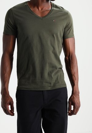 Camiseta de algodón color verde oliva con escote en V y mangas cortas. Presenta un pequeño logo en el pecho y un diseño cómodo y ajustado.