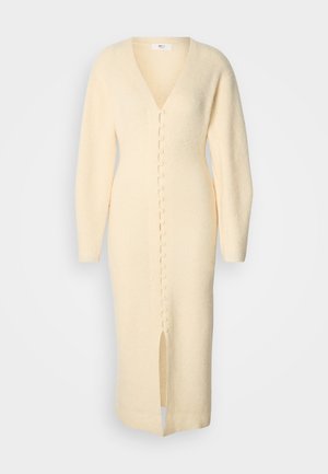 Long, cream colored knit dress with a V-neck, button-front closure, and a front slit, featuring long sleeves and textured fabric.