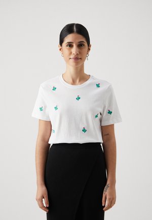 Witte katoen T-shirt met meerdere groene cactus borduursels met roze bloemen. Ronde hals, korte mouwen, losse pasvorm.