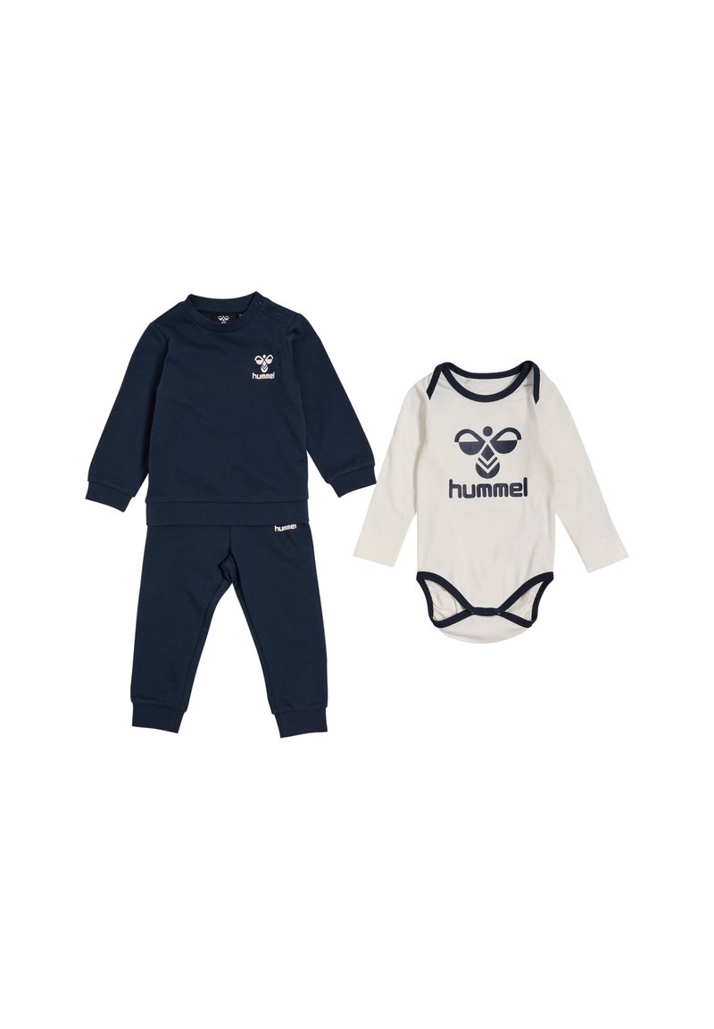 Marinblå tröja och byxor för småbarn, med en logotyp, i kombination med en krämfärgad långärmad body med marinblå detaljer och matchande logotyp.