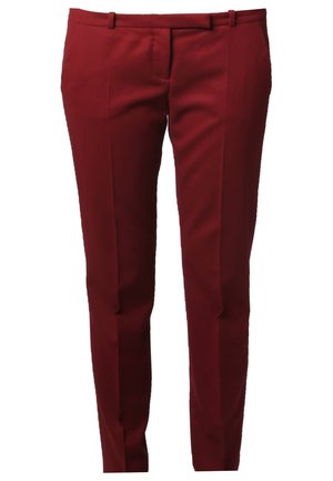 Woman wearing black long-sleeve top with lace detail, burgundy tailored pants, black ankle boots, and carrying a black shoulder bag.