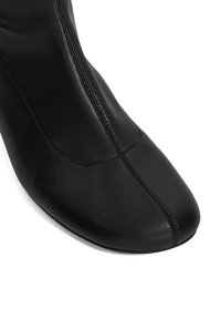 Black leather ankle boot with a pointed toe, vertical seam detailing, and smooth texture. Sturdy sole contrasts with the sleek upper.