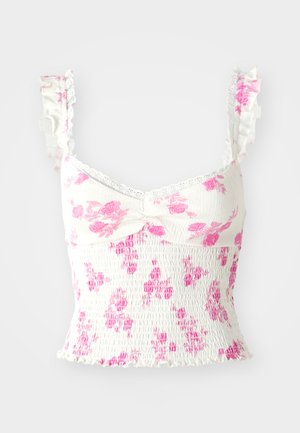 White floral crop top with pink patterns, ruffled straps, smocked bodice, and lace trim around the neckline.