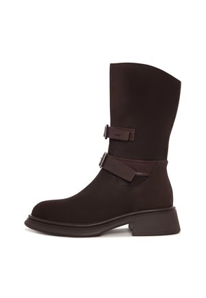 Stivali al ginocchio in suede marrone con due cinghie decorative, punta arrotondata e tacco spesso. Tessuto liscio con dettagli di cucitura minimi.
