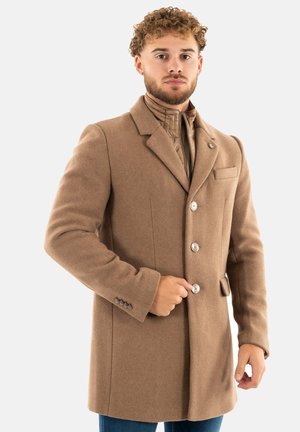 Cappotto di lana marrone con un design su misura, dotato di revers a lancetta, cinque bottoni, tasche laterali e una texture morbida.