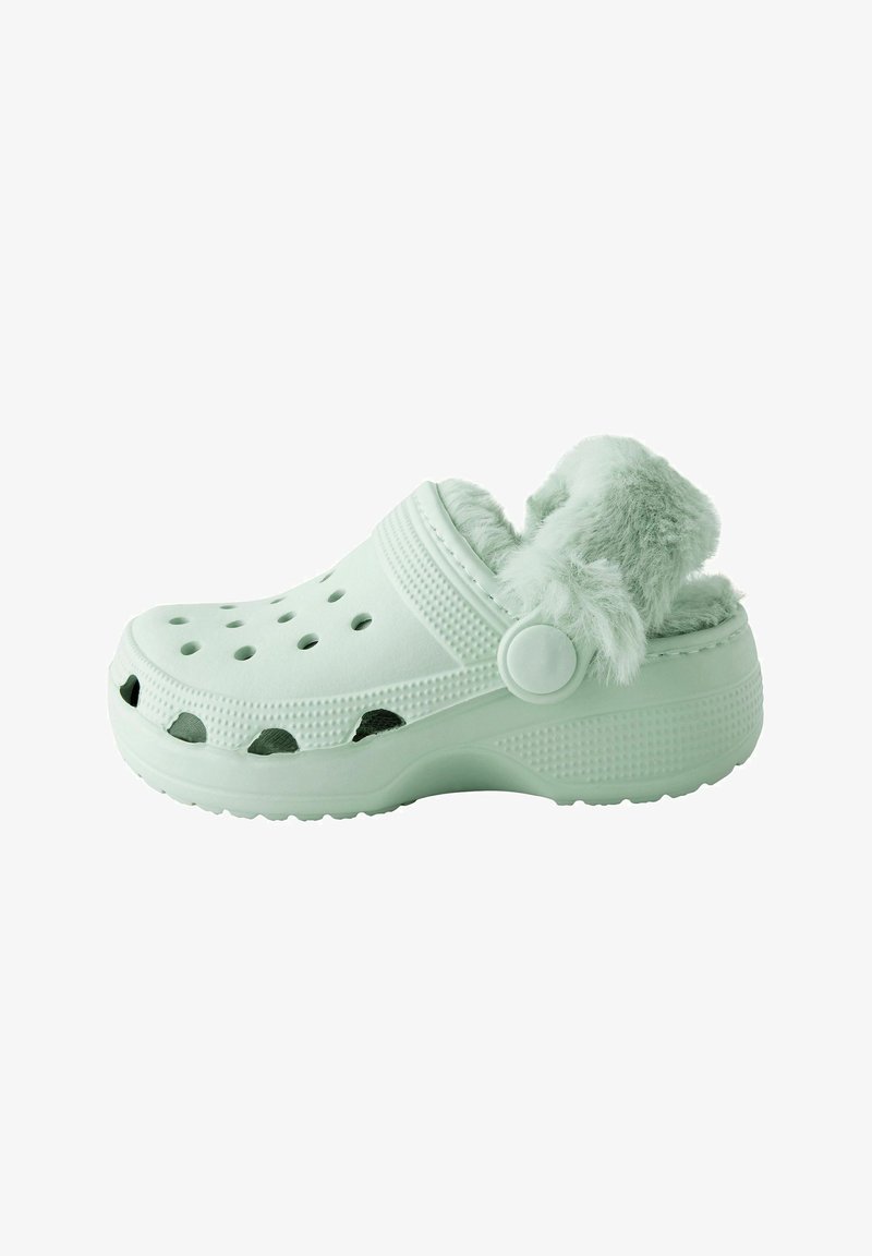 Sabot vert clair avec une doublure en fourrure douce et duveteuse. Fabriqué en matériau léger avec des trous de ventilation et une semelle texturée pour une meilleure adhérence.