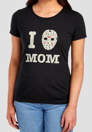 Black fitted T-shirt with “I” and a white hockey mask graphic above “MOM” text in distressed white font, worn with light blue jeans.