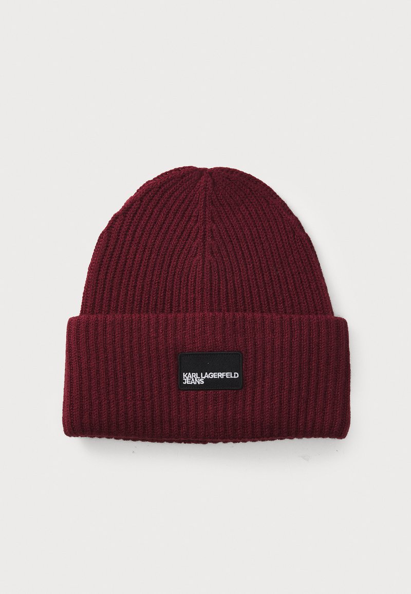Burgundy knit beanie with ribbed texture, featuring a black rectangular label with "KARL LAGERFELD JEANS" in white text on the front.