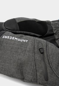 Guanto a metà in tessuto grigio con dettagli neri e logo. Presenta una tasca con zip e una superficie testurizzata per una migliore presa. Progettato per attività all'aperto.