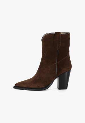 Braune Wildleder-Ankle-Boots mit spitz zulaufender Zehenpartie, seitlichen Nähten und einem robusten schwarzen Absatz. Mit einer Zuglasche für einfaches An- und Ausziehen.