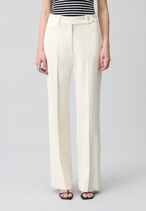 Pantaloni avorio a vita alta con una vestibilità sartoriale, pince, tasche laterali e dettaglio con cintura bottonata; design elegante e strutturato.
