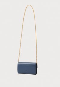 Temno modra usnjena crossbody torba s potegom pravokotne oblike, ki ima zlat pas in minimalističen dizajn.