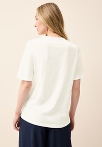 Bílé tričko s krátkým rukávem z měkké látky, s volným střihem a kulatým výstřihem, s rovnými lemy a minimalistickým designem.