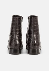 Bottines en cuir embossed crocodile marron avec une finition lisse, fermetures éclair à l'arrière et semelles en caoutchouc plates.