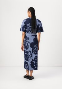 Rochie tricotată cu mâneci scurte, având un model floral albastru și bleumarin. Rochia este lungă, ajustată în talie și texturată.