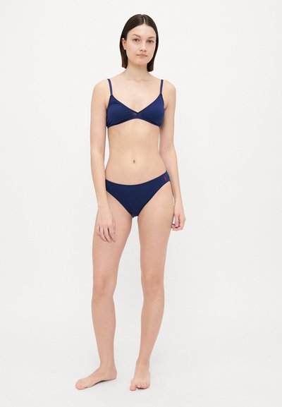 Navy blue bikini set featuring a triangular bra with thin straps and a low-rise bottom, both with scalloped edges and minimal branding.