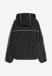 Fekete kapucnis dzseki fehér fényvisszaverő csíkkal a vállaknál, ujjainál és kapucniban, elasztikus mandzsettákkal és szegéllyel, hátulnézetben.