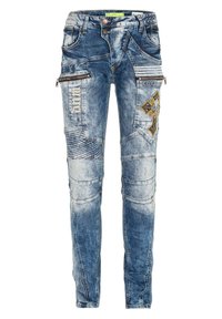 Blaue Jeans aus Denim mit einer engen Passform, dekorativen Steppnähten, mehreren Reißverschlusstaschen und einem bestickten Kreuzdetail auf der Vorderseite.