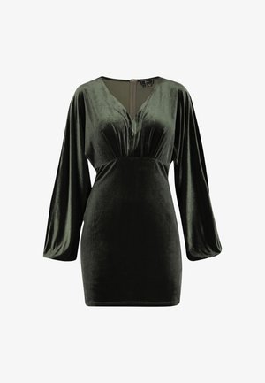 Grøn fløjlskjole med lange, brede ærmer, dyb V-udskæring og detalje med centr seam. Glat tekstur og tætsiddende silhuet. Lynlås lukning bagpå.