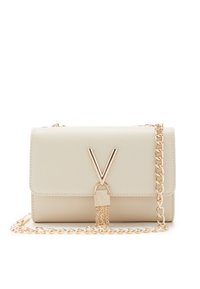 Krémová kabelka z prošívané kůže s zlatým řetízkovým popruhem, která má výrazný zlatý V-tvarovaný kovový prvek a bezpečné uzamykání.