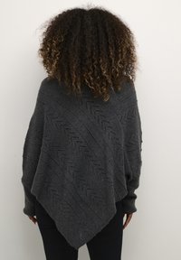 Poncho a maglia grigio scuro con motivo a zigzag, caratterizzato da un taglio asimmetrico e maniche lunghe, realizzato in un materiale morbido e testurizzato.