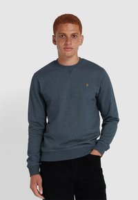 Donkergrijze sweatshirt met lange mouwen, ronde halslijn, elastische manchetten en zoom; heeft een klein gouden logo op de borst.