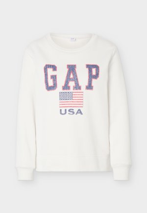 Λευκό φούτερ με μπλε και κόκκινα γράμματα "GAP", γραφικό της αμερικανικής σημαίας και το κείμενο "USA" από κάτω στο μπροστινό μέρος.