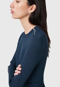 Meriininsinine ribattupaita pitkillä hihoilla, pyöreällä kaula-aukolla ja vetoketjydetalla olkapäällä. Ominaisuuksina istuva siluetti ja teksturoitu kangas.