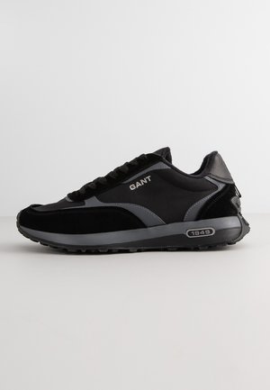 Black and gray GANT sneaker with laces, rubber sole, brand name on side, and "1949" detail on the midsole, shown in side profile.