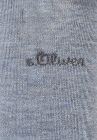 Tessuto blu con trama, in primo piano il nome del marchio "s. Oliver" ricamato in nero sullo sfondo.