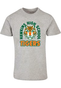 Graues T-Shirt mit kurzen Ärmeln, das ein orangenes und schwarzes Tiger-Design zeigt, ergänzt durch den Text "HAWKINS HIGH SCHOOL TIGERS" in grün und orange.