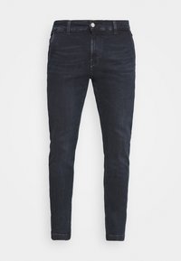 Mörkblå skinny jeans av denim, med en klassisk femficksdesign, bältesöglor och en framstående metallknappsstängning.