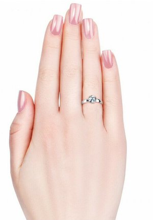 Zilveren ring met een centrale steen, gedragen op een hand met lange, lichtroze nagels tegen een effen witte achtergrond. Glad, minimalistisch ontwerp.