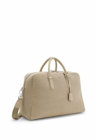 Sac de voyage beige texturé avec poignées doubles, bandoulière amovible et fermeture éclair, posé en angle sur fond blanc.