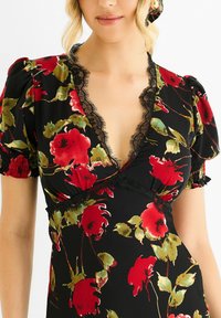 Black floral dress featuring red and green rose patterns, a deep V-neck with lace trim, and puffed short sleeves. Smooth fabric texture.