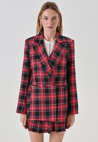 Rot und schwarz karierter Blazer mit doppelreihigen Knöpfen, scharfen Revers und einem passenden tartan Minirock mit Faltendetails.