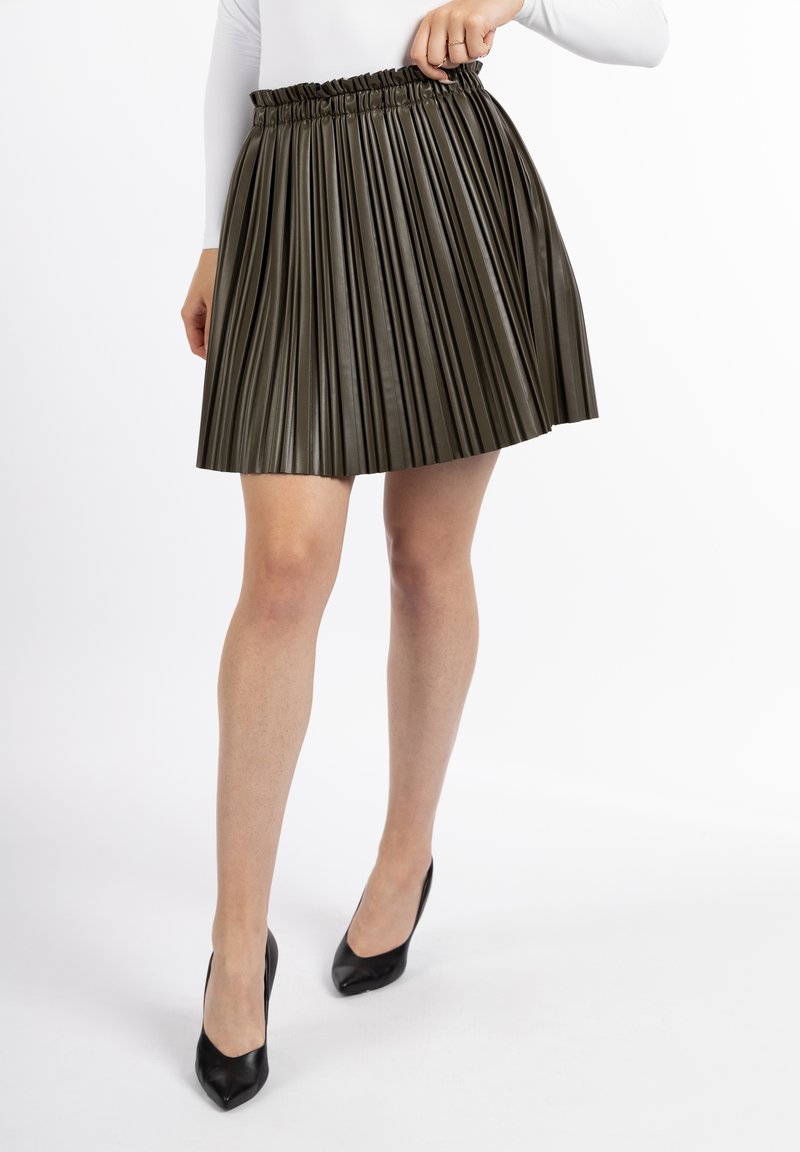 Pleated skirt in olive green, made of smooth synthetic material, featuring an elasticized waistband for comfort and a flared silhouette.