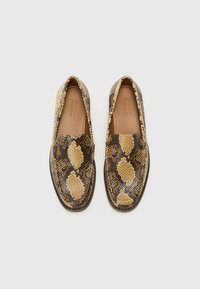 Mocassins à motif de peau de serpent avec une texture lisse, présentant des nuances de marron, beige et noir. Design arrondi avec une semelle plate.
