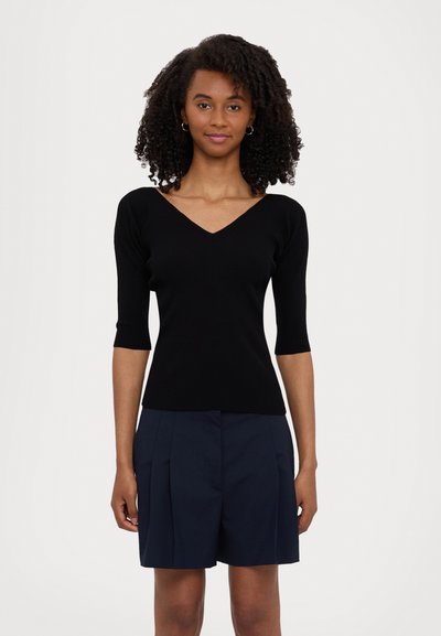 Top noir en tricot côtelé avec un col en V et des manches courtes, associé à un short bleu marine. Texture lisse et design ajusté. Simple et polyvalent.