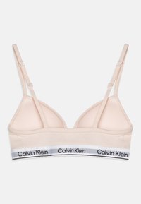 Világos rózsaszín, vezeték nélküli melltartó háromszög alakú kosarakkal, állítható pántokkal és fehér szalaggal, amelyen fekete "Calvin Klein" felirat található. Sima textúra.