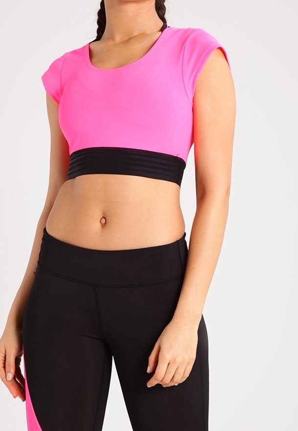 Crop top aderente a maniche corte di un vivace rosa con una cintura nera elastica. Abbinato a leggings neri a vita alta con un accento rosa.