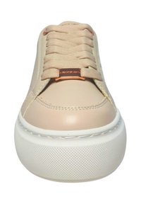 Sneakers in pelle sintetica beige con suola in gomma bianca texturizzata, dotati di lacci piatti e un accent metallico sulla linguetta.