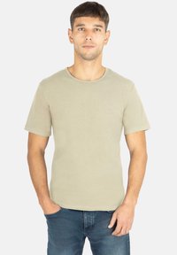 Beiges Kurzarm-T-Shirt aus Baumwolle mit Rundhalsausschnitt. Verfügt über ein minimalistisches Design und ein dezentes Logo-Detail auf der linken Brust.