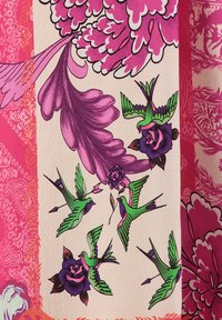 Bunt gewebter Stoff mit großen rosa Blumen, grünen Kolibris und lila Rosen auf einem rosa Hintergrund mit filigranen Mustern.