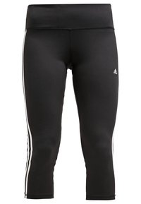Leggings de sport noirs raccourcis avec des bandes blanches sur les côtés et un petit logo Adidas sur la cuisse supérieure.