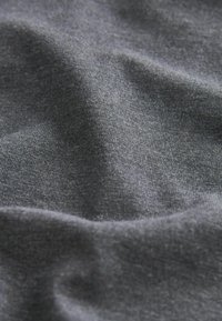 Dunkelgrauer Stoff mit einer weichen, glatten Textur, die subtile Falten und einen leichten Glanz aufweist, was auf ein leichtes Material hinweist.