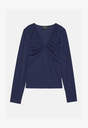 Camiseta de manga larga de color navy con escote en V, detalle fruncido en el frente y una textura suave. Diseño simple con acentos mínimos.