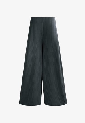 Nohavice so širokými nohavicami v tmavosivej farbe s vertikálnou rebrovanou textúrou, vysokým pásom a bočnými rozparkami pre pohodlný pohyb. Strih je upravený na voľný a pohodlný fit.